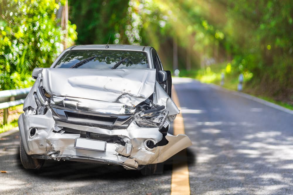 Gray car with significant accident damage on a Portland, Oregon road.