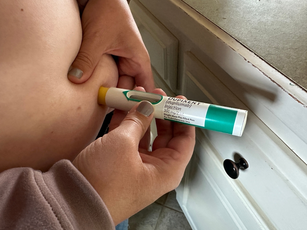 woman injecting herself with dupixent pen